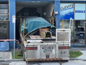 Truckie trapped in building crash