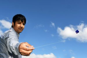 Refugee flies a kite for his future